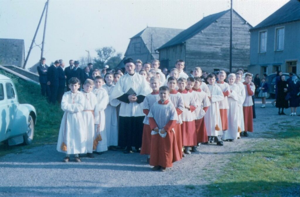 L'abbé Buché, curé de La Romagne (Ardennes), entouré d'enfants de chœur du village et des paroisses environnantes.
