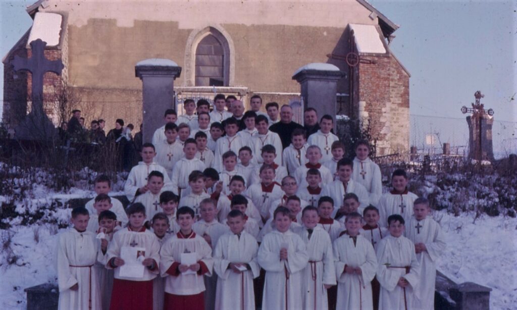 Monseigneur François Marty et enfants de chœur devant l'église Saint-Jean à La Romagne (Ardennes).