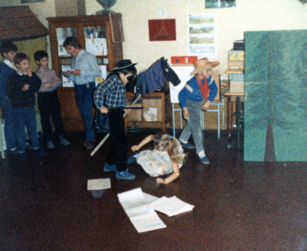 Noël 1987, école de La Romagne, saynète, cow-boys tirant au revolver et cheval bâton. Photographie ancienne en couleurs, collection privée, avec l’aimable autorisation de monsieur Pierre Fleury.