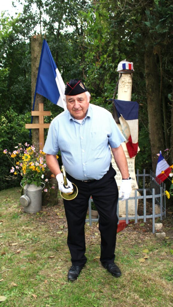 Trois porte-drapeau de Union nationale des combattants de Chaumont-Porcien (Ardennes), monsieur Michel Mauroy de La Romagne (Ardennes) avec son clairon, stèle des fusillés de Wadimont (Ardennes) avec un drapeau du comité de Chaumont-Porcien (Ardennes) du Souvenir français, une croix de Lorraine et d'autres symboles de la Résistance française. Prise de vue effectuée le vendredi 30 août 2024 à Wadimont (Ardennes). Crédits photographiques : © 2020 laromagne.info par Marie-Noëlle ESTIEZ BONHOMME.