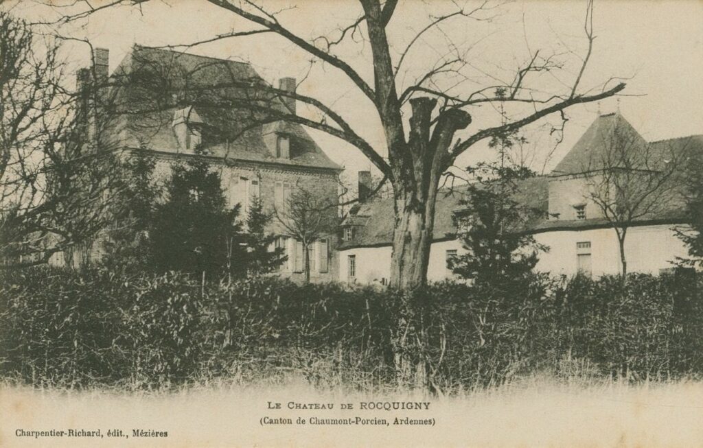 Autrefois, une haie touffue encerclait le château de Rocquigny (Ardennes), formant un mur végétal. Cette barrière naturelle, aujourd’hui disparue, demeure visible sur cette source iconographique, témoin d’un paysage transformé. Archives départementales des Ardennes, 8Fi 8 [série Fi = documents figurés et assimilés entrés par voie extraordinaire, sous-série 8Fi = cartes postales], carte postale ancienne en noir et blanc consultable en ligne.