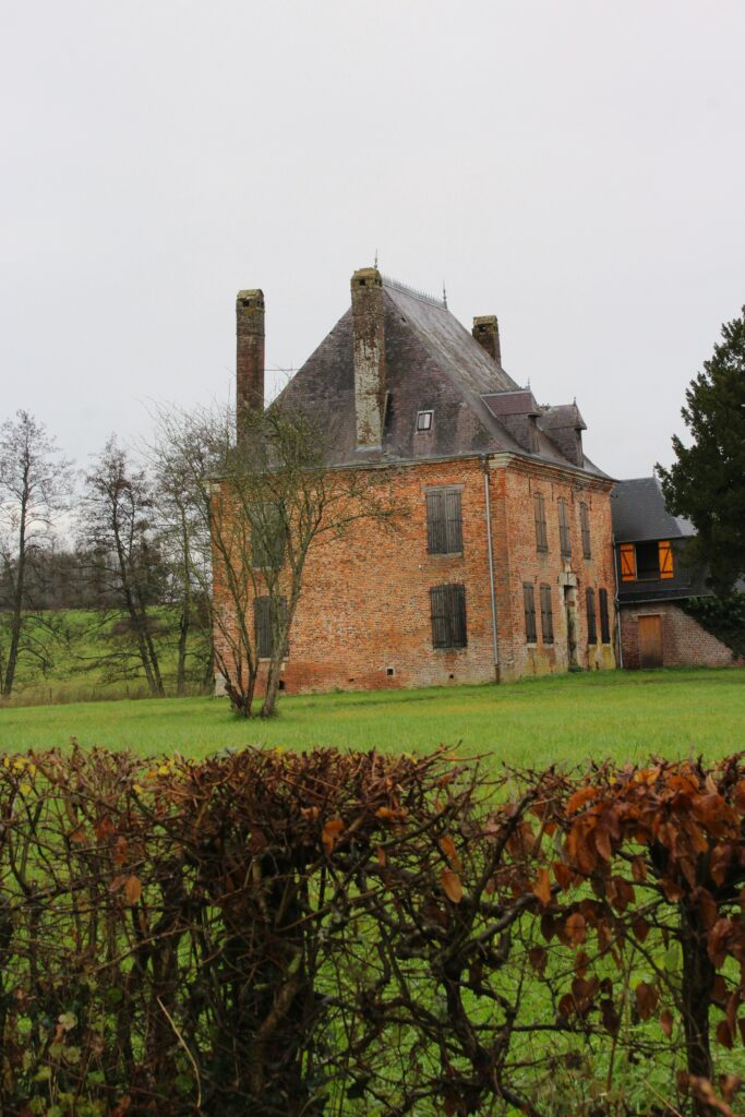 Les façades sud du château de Rocquigny (Ardennes) et des communs révèlent un contraste entre le domaine principal et les bâtiments annexes. Autrefois, ces derniers abritaient des écuries, remplacées par un préau. Photographies en couleurs, prises de vue effectuées le jeudi 12 septembre et le mercredi 18 décembre 2024. Crédits photographiques : © 2020 laromagne.info par Marie-Noëlle ESTIEZ BONHOMME.