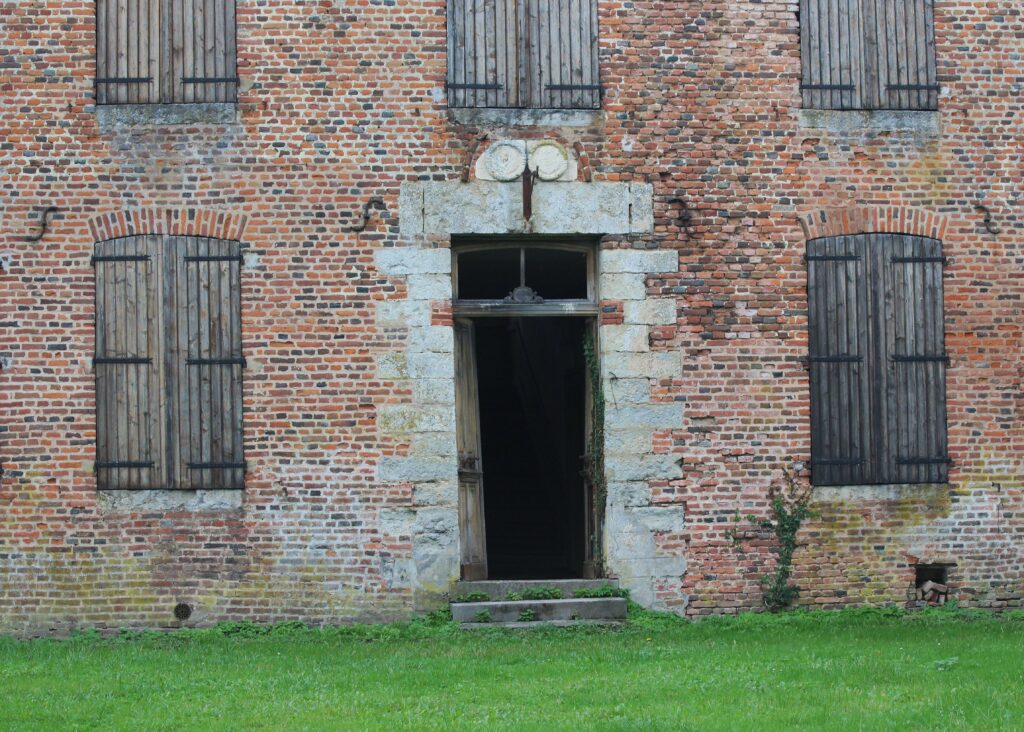 Le château de Rocquigny (Ardennes), dont la structure est principalement construite en briques, se distingue par des détails architecturaux en pierre, tels que les encadrements des portes ou les appuis des fenêtres. Photographies en couleurs, prises de vue effectuées le jeudi 12 septembre, le vendredi 18 octobre, le mercredi 18 décembre 2024. Crédits photographiques : © 2020 laromagne.info par Marie-Noëlle ESTIEZ BONHOMME.