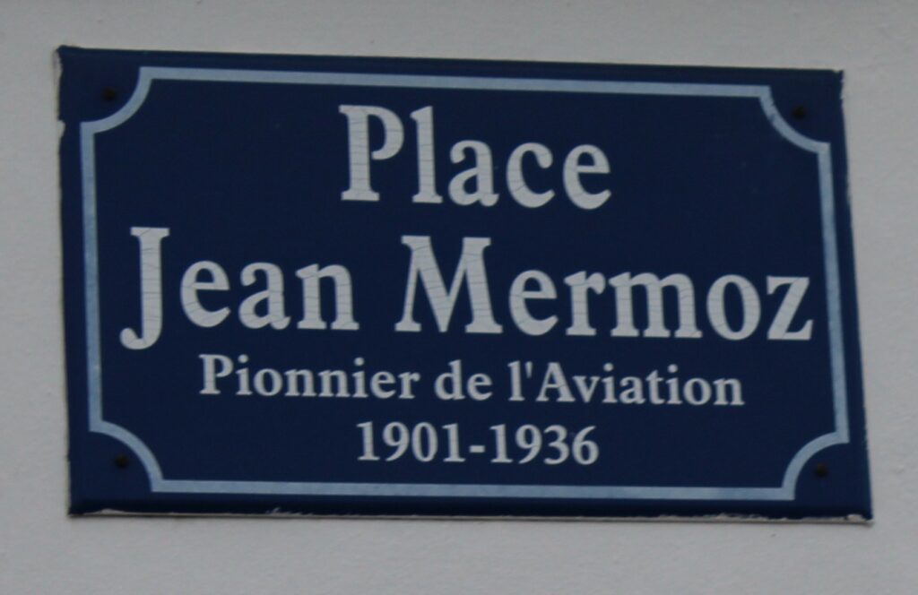 Cette plaque de la rue Jean Mermoz à Rocquigny (Ardennes) rend hommage à l’aviateur français, figure emblématique de l’Aéropostale, disparu en mer en 1936. Prise de vue effectuée le mercredi 18 décembre 2024. Crédits photographiques : © 2020 laromagne.info par Marie-Noëlle ESTIEZ BONHOMME.