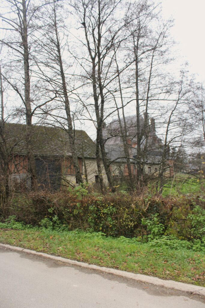 Façade nord du château de Rocquigny (Ardennes), avec une vue qui s’ouvre sur les communs partiellement dissimulée derrière un rideau d’arbres. Photographies en couleurs, prises de vue effectuées le jeudi 12 décembre 2024. Crédits photographiques : © 2020 laromagne.info par Marie-Noëlle ESTIEZ BONHOMME.