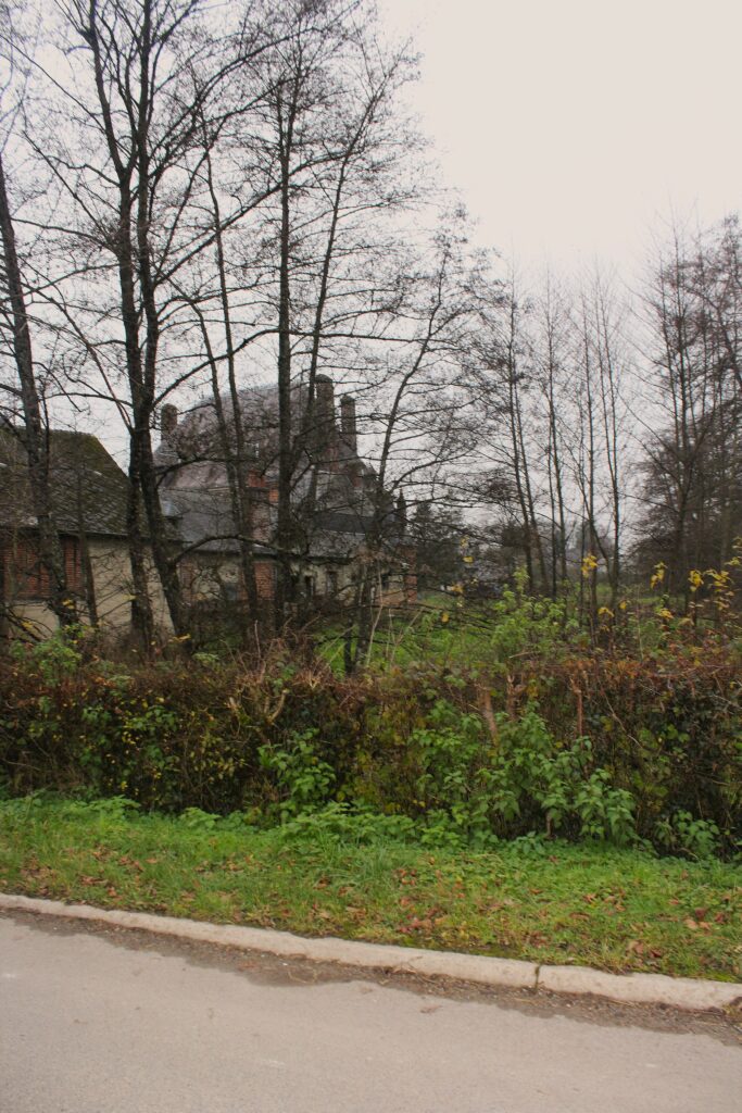 Façade nord du château de Rocquigny (Ardennes), avec une vue qui s’ouvre sur les communs partiellement dissimulée derrière un rideau d’arbres. Photographies en couleurs, prises de vue effectuées le jeudi 12 décembre 2024. Crédits photographiques : © 2020 laromagne.info par Marie-Noëlle ESTIEZ BONHOMME.