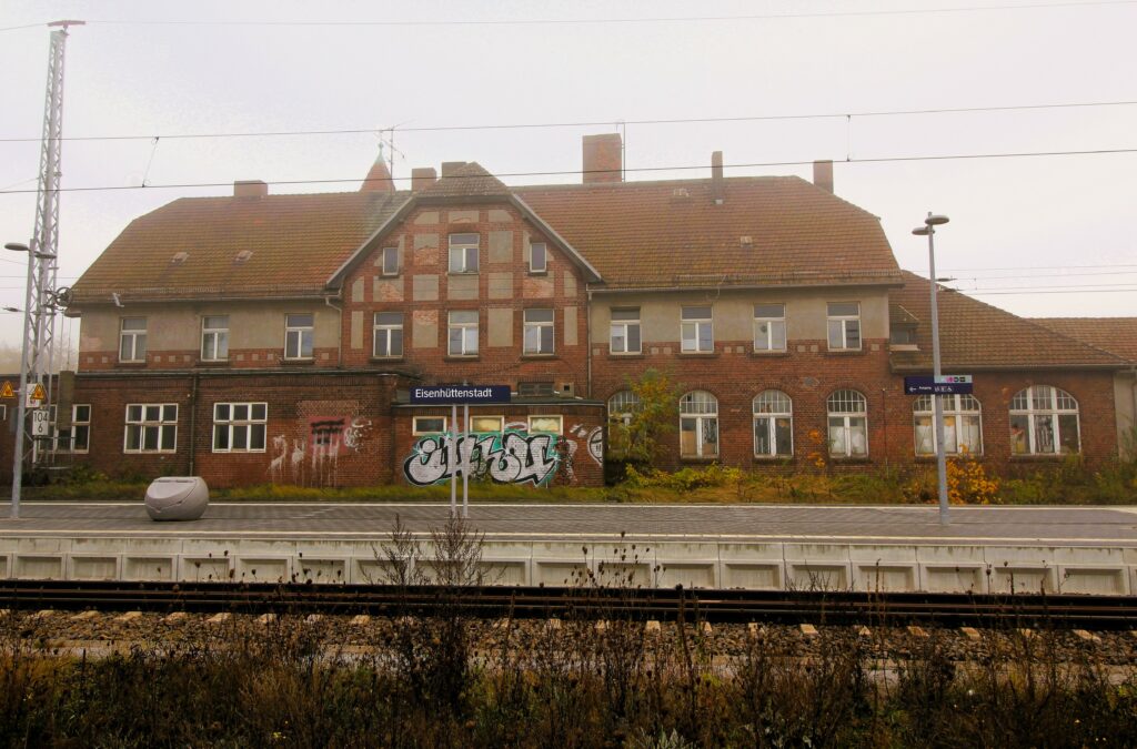 Façade arrière de la gare (partie ancienne) à Eisenhüttenstadt (Allemagne), dans le quartier de Fürstenberg (Oder). Photographies en couleurs, prises de vue effectuées le vendredi 25 octobre 2024. Crédits photographiques : © 2020 laromagne.info par Marie-Noëlle ESTIEZ BONHOMME.