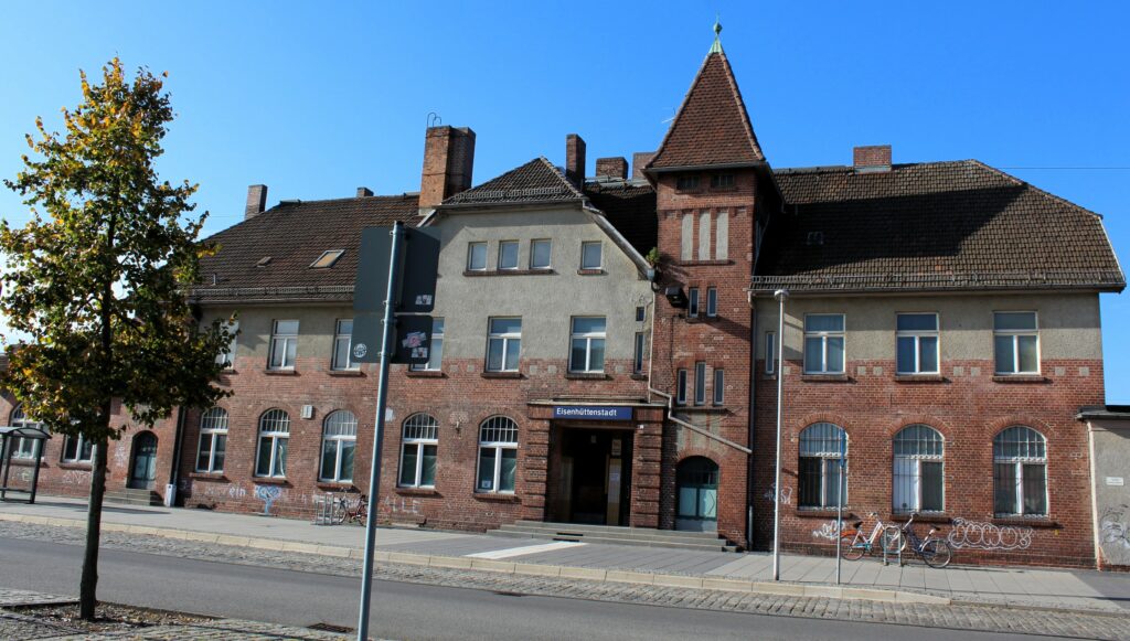 Façade principale de la gare (partie ancienne) à Eisenhüttenstadt (Allemagne), dans le quartier de Fürstenberg (Oder). Photographies en couleurs, prises de vue effectuées le vendredi 25 octobre 2024. Crédits photographiques : © 2020 laromagne.info par Marie-Noëlle ESTIEZ BONHOMME.