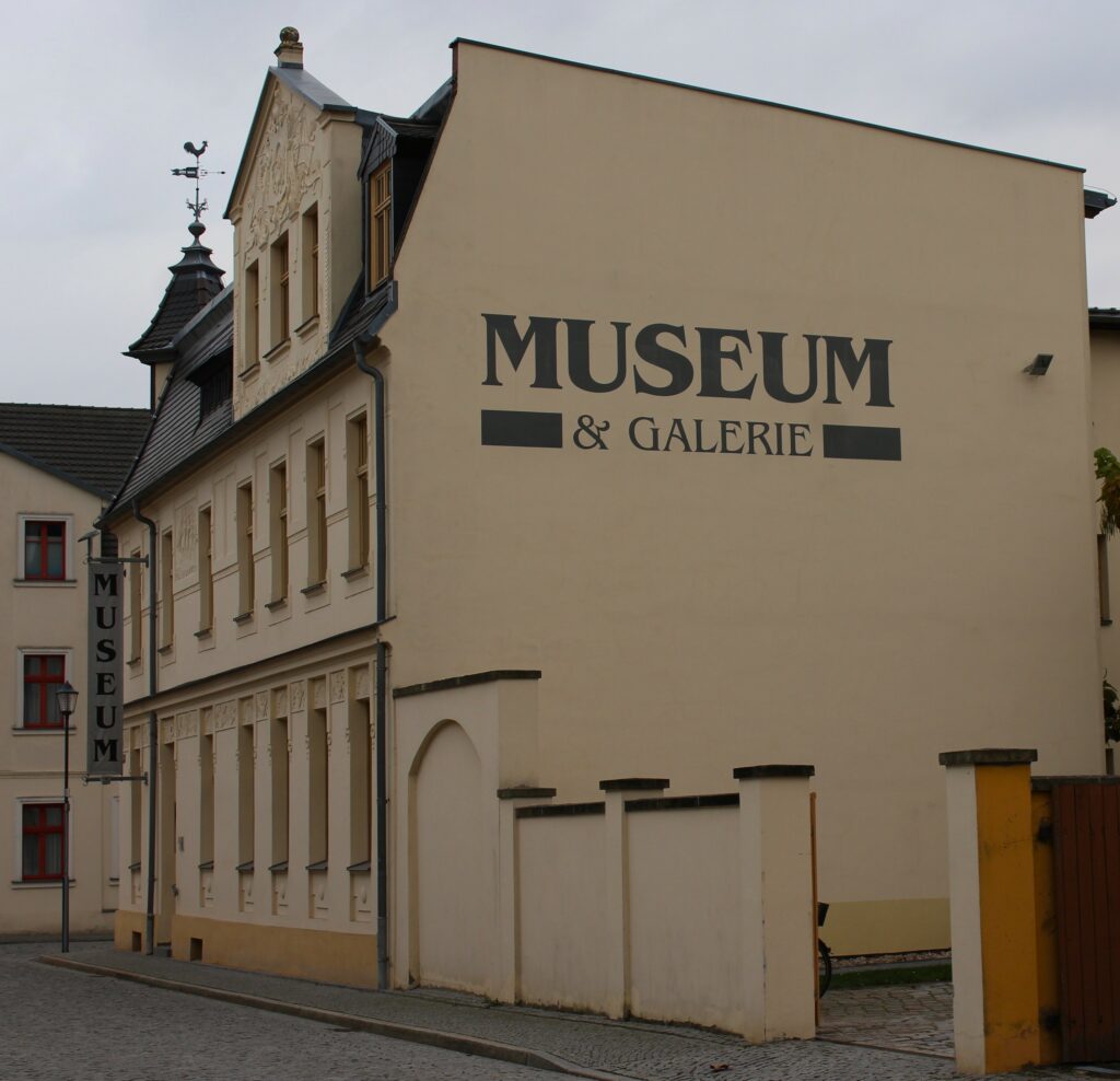 Entrée du musée municipal d'Eisenhüttenstadt (Allemagne), dans le quartier de Fürstenberg (Oder). Avec l'aimable autorisation du Städtisches Museum & Galerie, Löwenstraße 4, 15890 Eisenhüttenstadt. Photographie en couleurs, prise de vue effectuée le mercredi 30 octobre 2024. Crédits photographiques : © 2020 laromagne.info par Marie-Noëlle ESTIEZ BONHOMME.