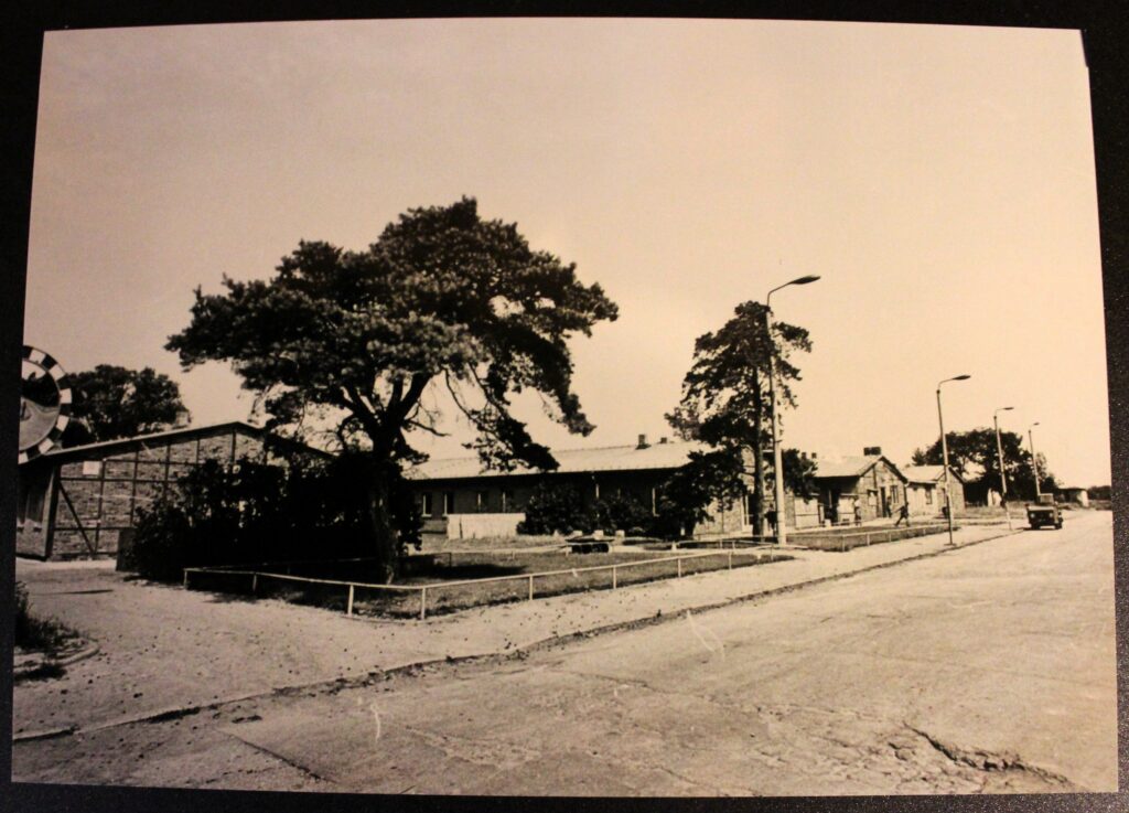 Le miroir routier ou miroir de sécurité qui se voit à gauche a pour but d’améliorer la visibilité dans les zones où le champ de vision est réduit, notamment aux intersections. Entrée du Stalag III-B Fürstenberg (Oder). Photographie ancienne en noir et blanc, virage sépia, tirage argentique (collection privée, avec l'aimable autorisation de monsieur Erich Opitz).