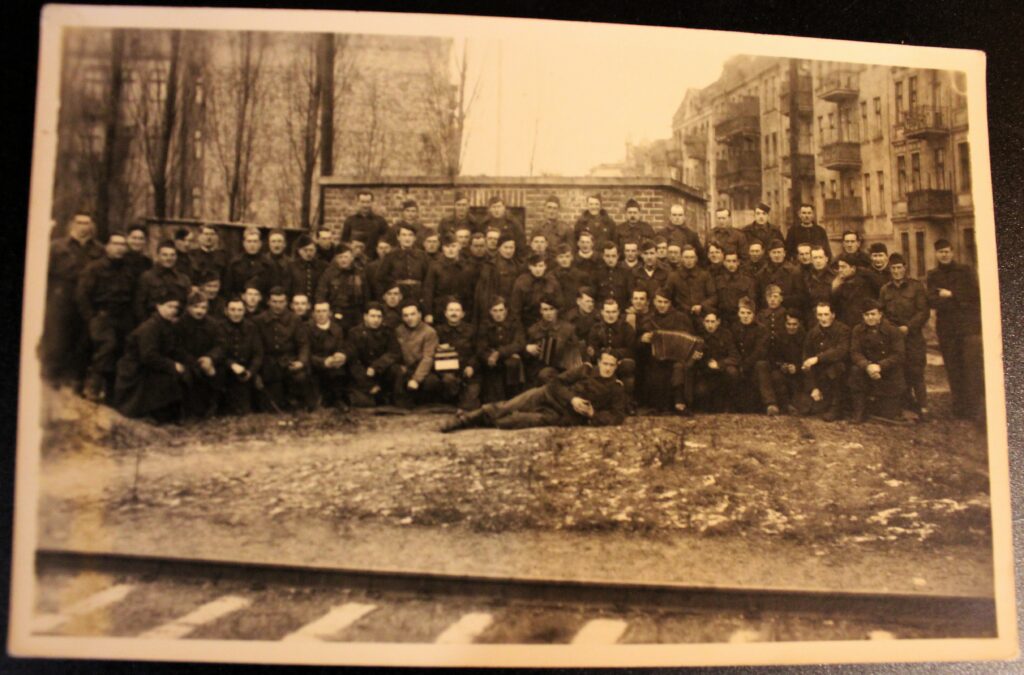 Groupe de prisonniers, dont des joueurs d'accordéon, au Stalag III-B Fürstenberg (Oder). Photographie ancienne en noir et blanc, virage sépia, tirage argentique (collection privée, avec l'aimable autorisation de monsieur Erich Opitz).