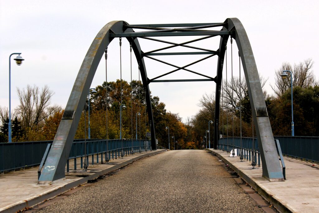 „An der Stelle der am 23.04.1945 gesprengten Brücke entstand in den Jahren 1995/96 diese „Neue Deichbrücke“. Ermöglicht wurde der Wiederaufbau durch Gelder des Landes Brandenburg, der Stadt Eisenhüttenstadt und vieler Bürger aus Fürstenberg/Oder, die nach Ende des 2. Weltkrieges für diese Brücke spendeten.“
Photographie en couleurs, prise de vue effectuée à Eisenhüttenstadt (Allemagne), dans le quartier de Fürstenberg (Oder) le mardi 29 octobre 2024. Crédits photographiques : © 2020 laromagne.info par Marie-Noëlle ESTIEZ BONHOMME.