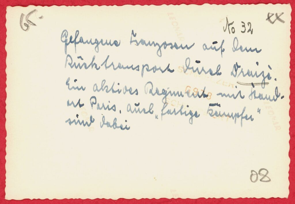 Photographie ancienne, tirage argentique en noir et blanc viré au sépia, sur papier à bords dentelés. Toute reproduction, totale ou partielle, est strictement interdite sans autorisation expresse de l’auteure. Au verso, une inscription manuscrite à l’encre bleu-noir indique : « Gefangene Franzosen auf dem Rücktransport durch Draize. Ein aktives Regiment mit Standort Paris. Auch ‘farbige Kämpfer’ sind dabei. », ce qui signifie « Prisonniers français lors de leur rapatriement par Draize. Un régiment actif basé à Paris. Des ‘combattants de couleur’ sont également présents. » (Exemplaire conservé dans la collection personnelle de l’auteure.)