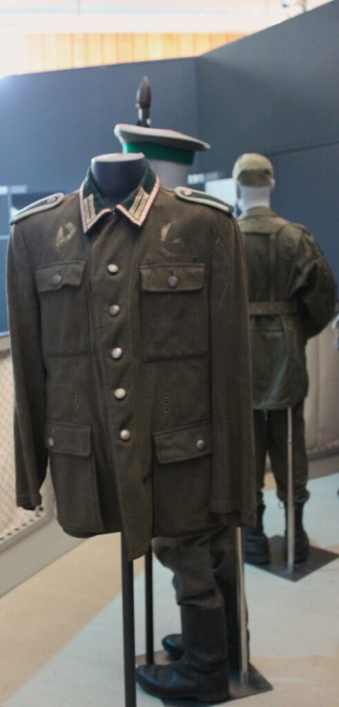 Feldbluse (vareuse de campagne du soldat allemand), marquée des initiales « PG » pour prisonnier de guerre. Prise de vue effectuée le lundi 5 mai 2025 au musée Guerre et Paix en Ardennes (Novion-Porcien, Ardennes). Crédits photographiques : © 2020 laromagne.info par Marie-Noëlle ESTIEZ BONHOMME.