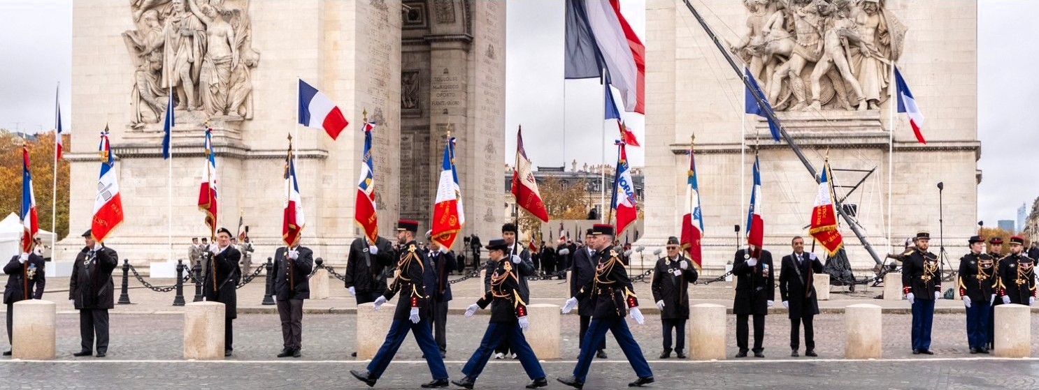 Au niveau national, le Président de la République a dirigé la cérémonie du 11 novembre 2025 à l’Arc de Triomphe, à Paris (Île-de-France), symbole de la Victoire et de la Paix, pour rendre hommage aux sacrifices des générations passées. Trois militaires marchent au pas, en ordre serré, devant les porte-drapeaux, en hommage aux soldats et aux victimes de guerre. Crédits photographiques : site institutionnel de la Présidence de la République. Reproduction autorisée sous licence ouverte, avec mention de la source et lien vers le portail officiel de l'Élysée.