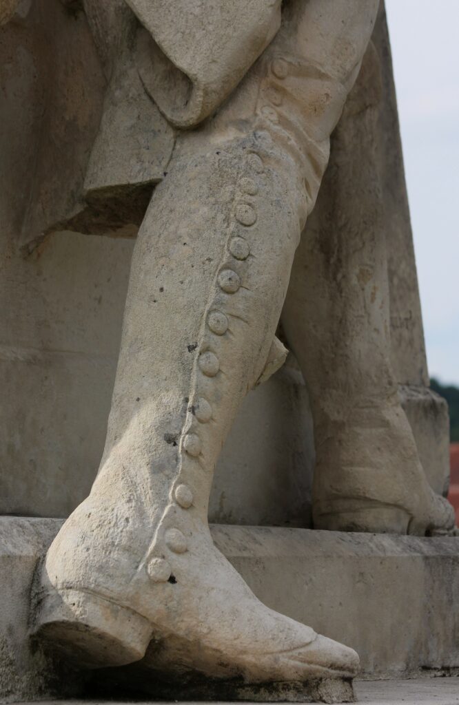Soldat vu de dos ; catogan ; guêtres sur bottes. Détails du monument à la gloire du général du Merbion (1737-1797) à Montmeillant (Ardennes). Photographies en couleurs, prises de vue effectuées le dimanche 3 septembre 2017. Crédits photographiques : © 2020 laromagne.info par Marie-Noëlle ESTIEZ BONHOMME.