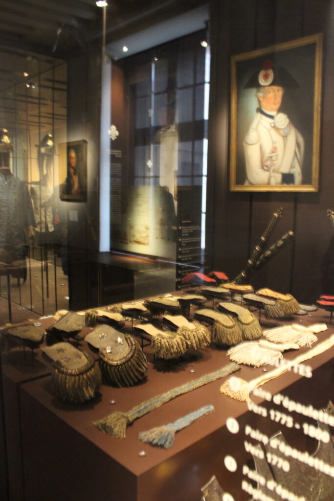 Sous l’Ancien Régime, les grades dans l’armée royale sont indiqués par des signes distinctifs portés sur l’uniforme, notamment les épaulettes. Musée de l’Armée – hôtel des Invalides. Photographie en couleurs, prise de vue effectuée le jeudi 8 janvier 2026. Crédits photographiques : © 2020 laromagne.info par Marie-Noëlle ESTIEZ BONHOMME.