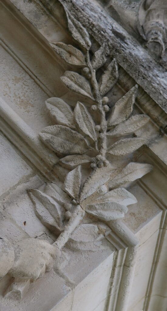 La branche sculptée représente très probablement du laurier (laurier noble, Laurus nobilis). Détail du monument à la gloire du général du Merbion (1737-1797) à Montmeillant (Ardennes). Photographie en couleurs, prise de vue effectuée le dimanche 3 septembre 2017. Crédits photographiques : © 2020 laromagne.info par Marie-Noëlle ESTIEZ BONHOMME.