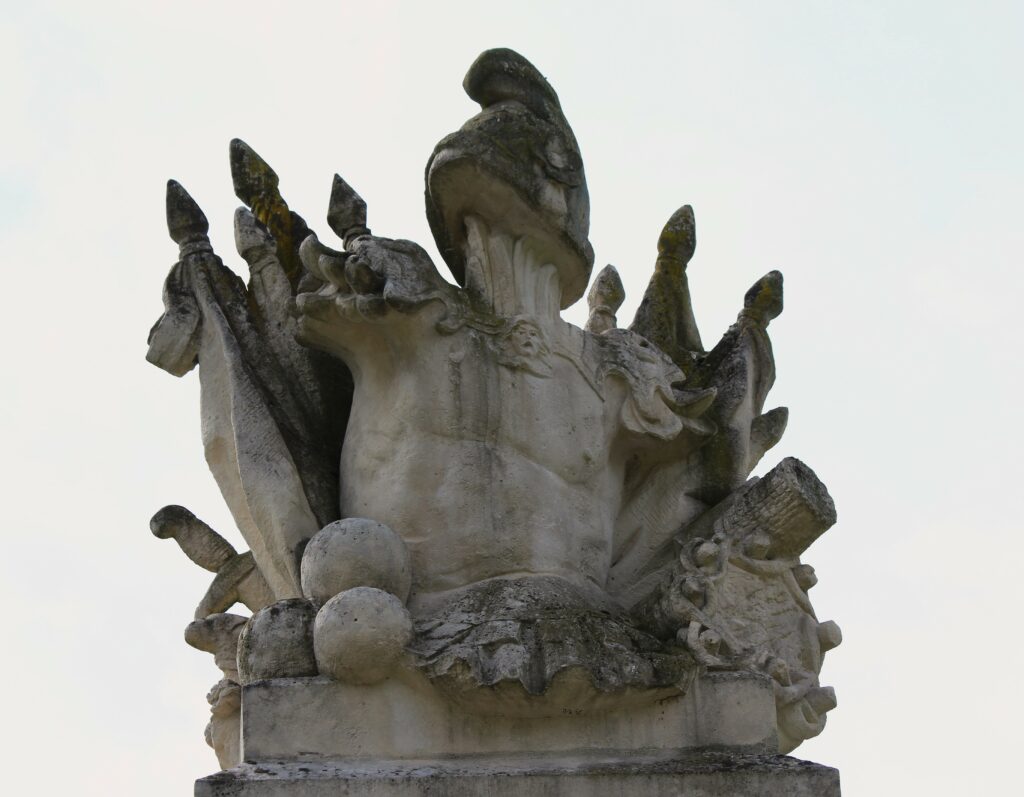 Trophée composé d’attributs militaires et surmonté d’un bonnet phrygien. Détail du monument à la gloire du général du Merbion (1737-1797) à Montmeillant (Ardennes). Photographie en couleurs, prise de vue effectuée le dimanche 3 septembre 2017. Crédits photographiques : © 2020 laromagne.info par Marie-Noëlle ESTIEZ BONHOMME.