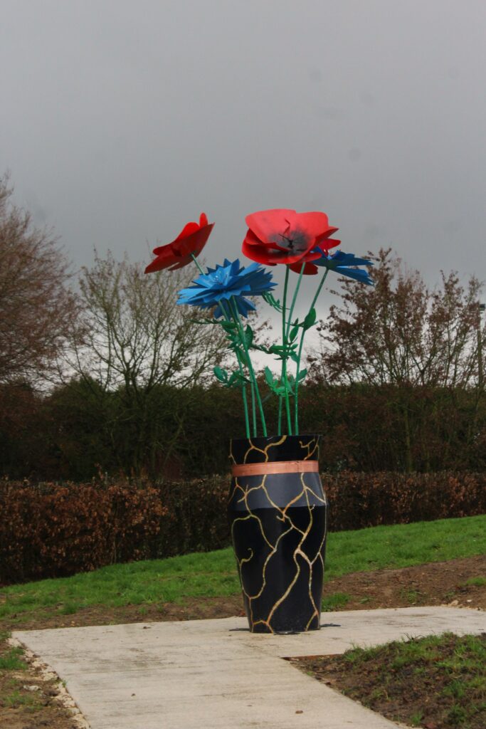 Vase japonais Œuvre pour la paix Made in Metal IV au musée Guerre et Paix (Novion-Porcien, Ardennes). Cette œuvre respecte la tradition du kintsugi, une réparation des céramiques cassées avec du laque et de la poudre d’or, symbole de résilience et de beauté dans l’imperfection (wabi-sabi). Photographie en couleurs, prise de vue effectuée le vendredi 19 décembre 2025. Crédits photographiques : © 2020 laromagne.info par Marie-Noëlle ESTIEZ BONHOMME.