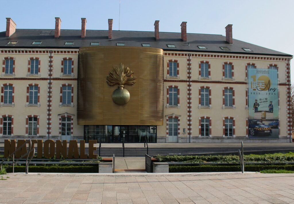 Façade principale du musée de la Gendarmerie (Melun), et grenade. Photographie en couleurs, prise de vue effectuée le jeudi 5 mars 2026. Crédits photographiques : © 2020 laromagne.info par Marie-Noëlle ESTIEZ BONHOMME.